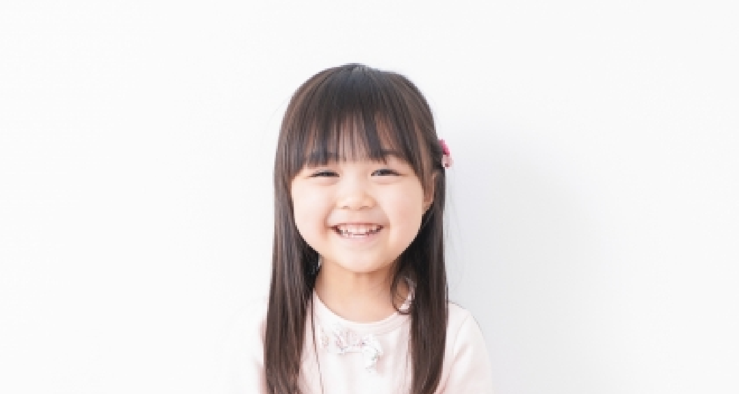 画像：歯を見せてほほ笑む女の子